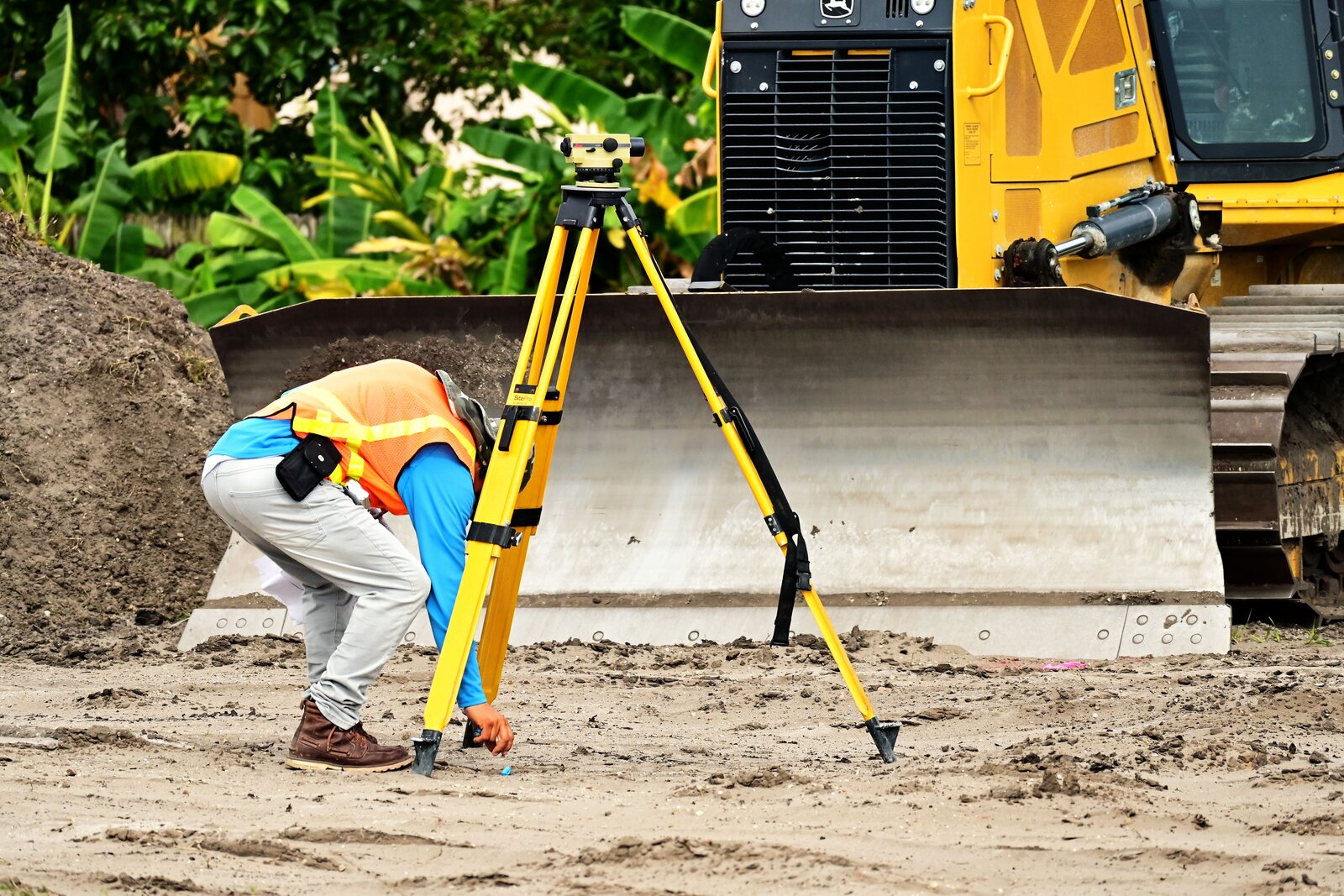 Géomètre préparant un niveau optique sur un chantier de terrassement